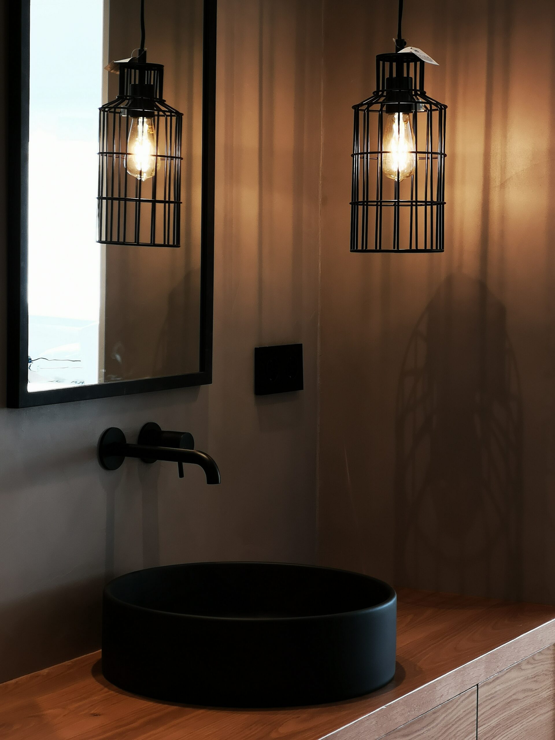 Detalle lavabo con griferia y lampara colgante en negro